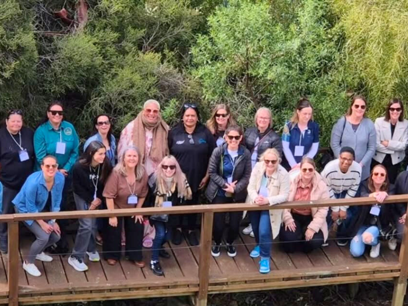 Group of people posing on a walking bridge.