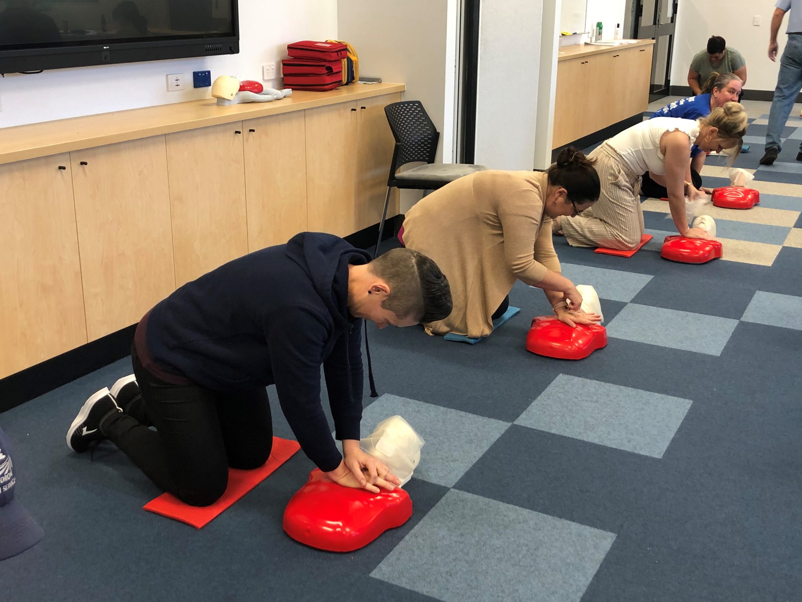 People practising CPR on dummies