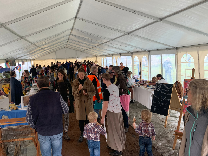 Image of an artisan tent with lots of people.