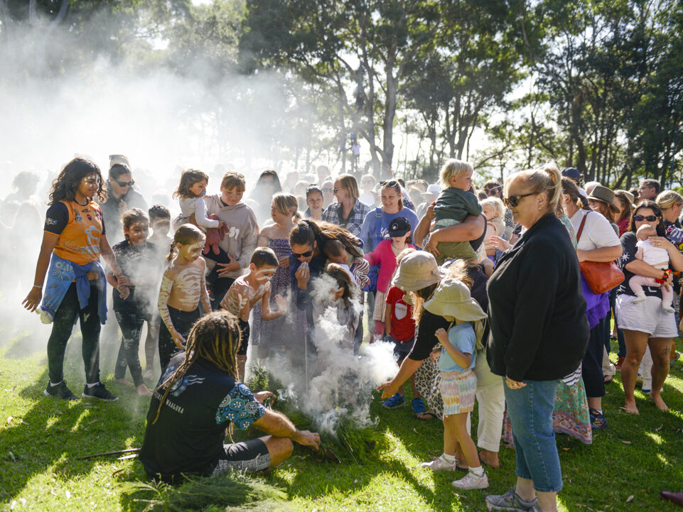 Group of people standing together around cultural smoking ceremony