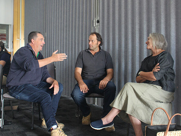 Three people sitting on chairs in a semi-circle.