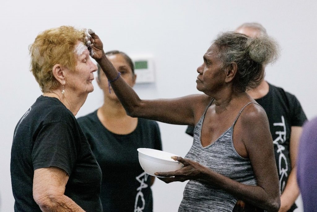 HEADING: Grey Panthers’ dancing their way to health and vitality through celebrating Aboriginal culture. IMAGE: Janet Munyarryun applying ocher to a Grey Panther.