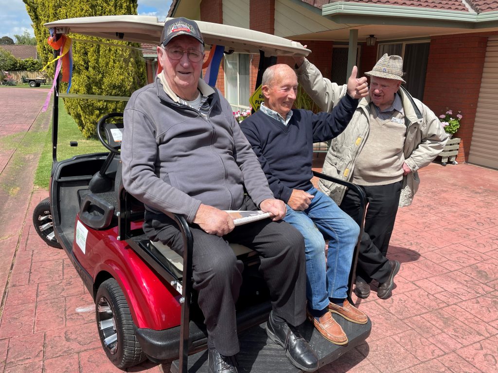 Evertide Residents sitting in golf buddy.
