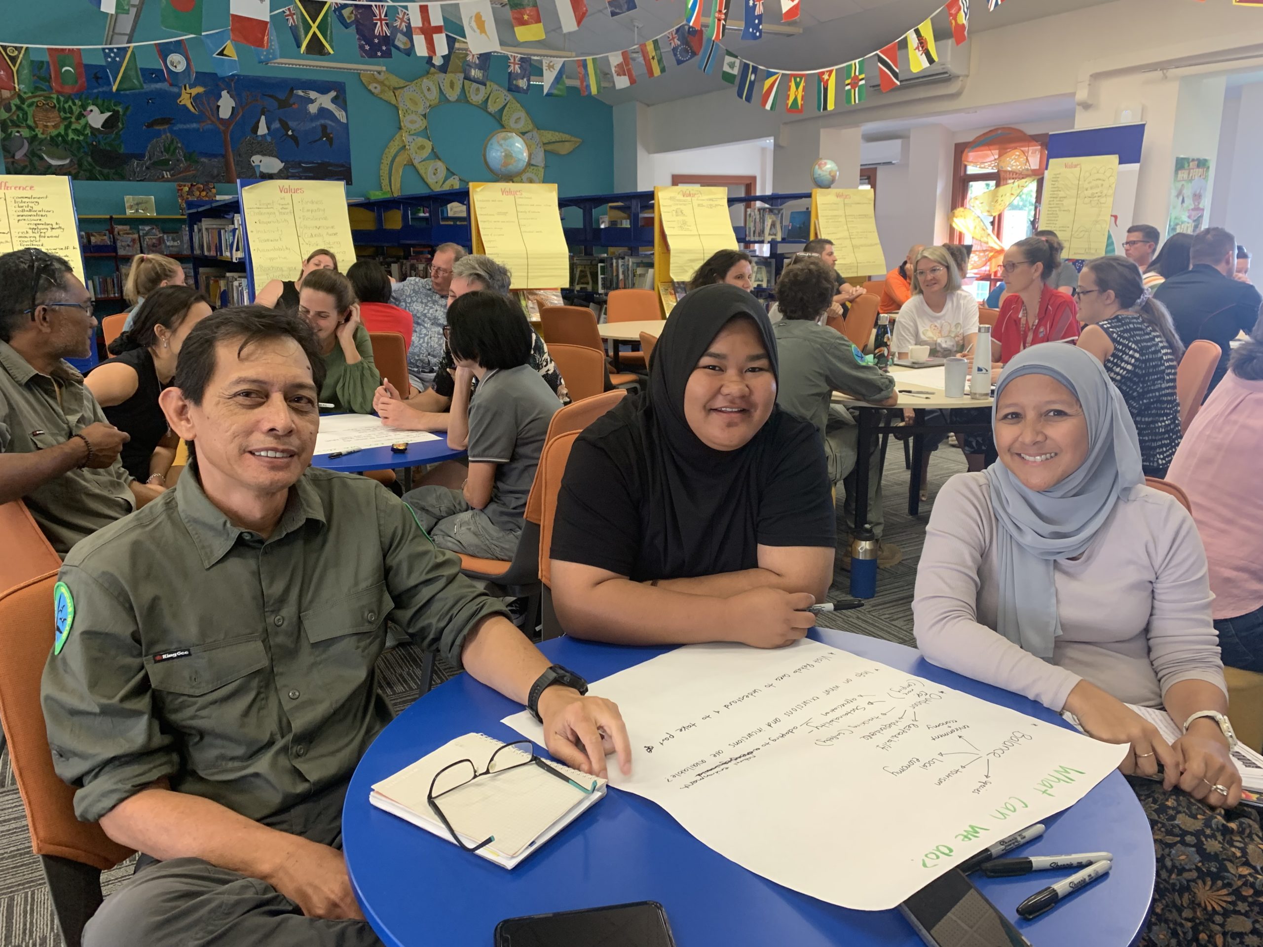 HEADING: Nearly $800,000 awarded to strengthen rural communities. IMAGE: Three people sitting at a table smiling and facing the camera.
