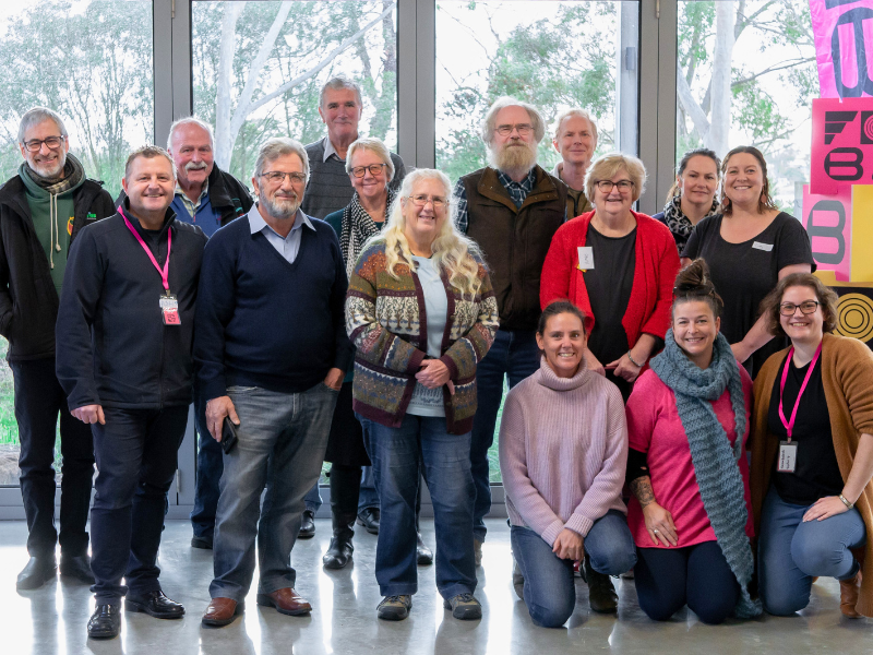Group of people cluster together for a photo.
