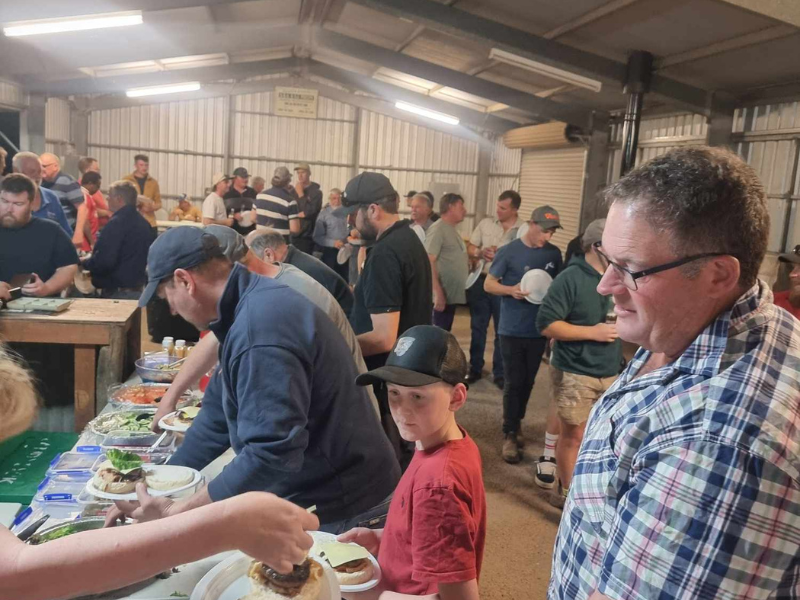 A man and a young boy are collecting food from a buffet-style set-up.