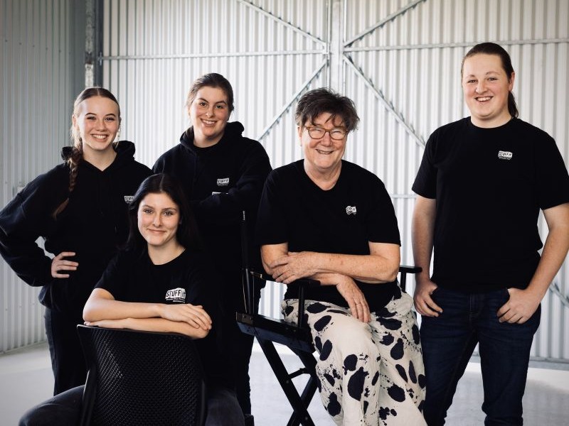 Group of five people smiling and looking front on.