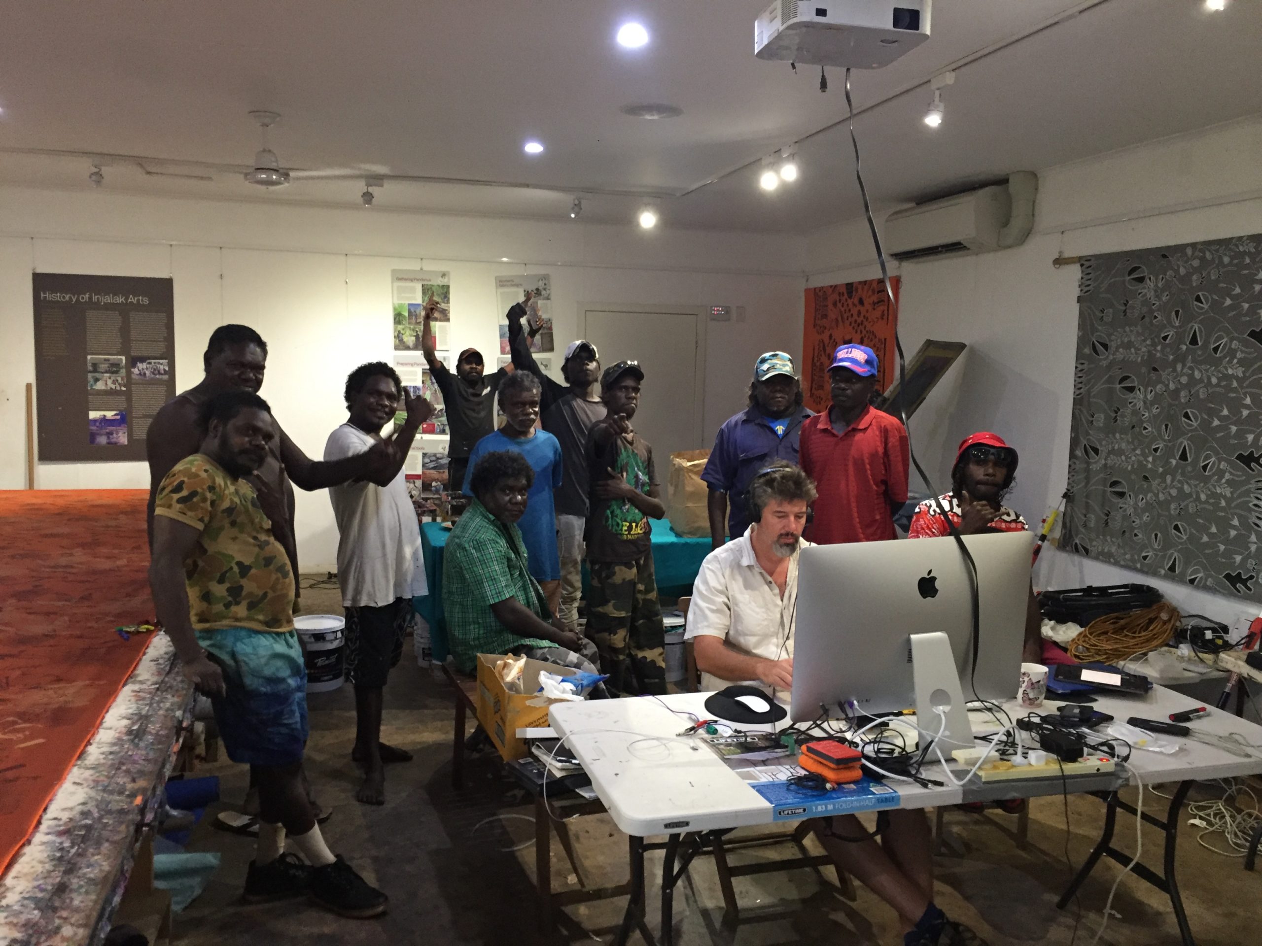 A group of men stand in a room during production workshops at Injalak Arts, Gunbalanya