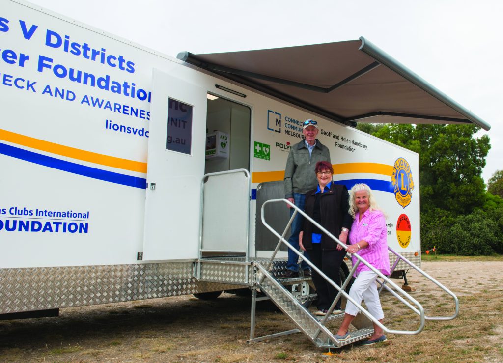 People standing on the steps leading up to the Lions mobile cancer screening unit