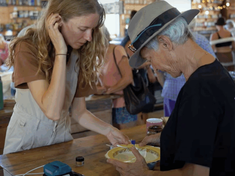 Two women working together to repair a broken bowl.