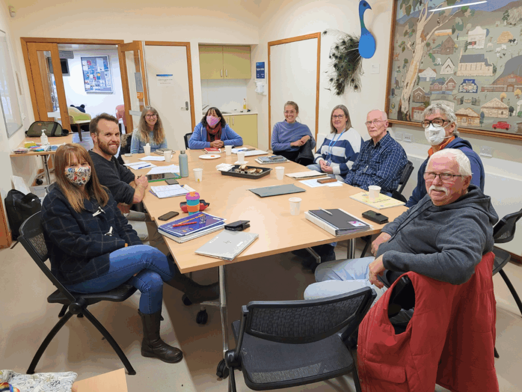 Group of people sit around a table at a committee meeting. 