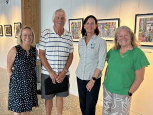Four adults standing in art gallery exhibition space