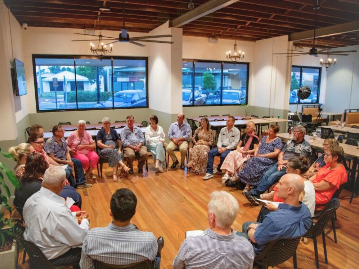 Community meeting with adults seated in a circle